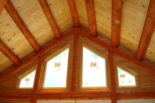Exposed wooden ceiling beams made from whole logs give this cabin a handmade look.
