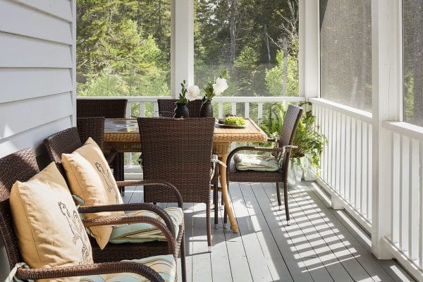 Outdoor furniture on a screened in porch.